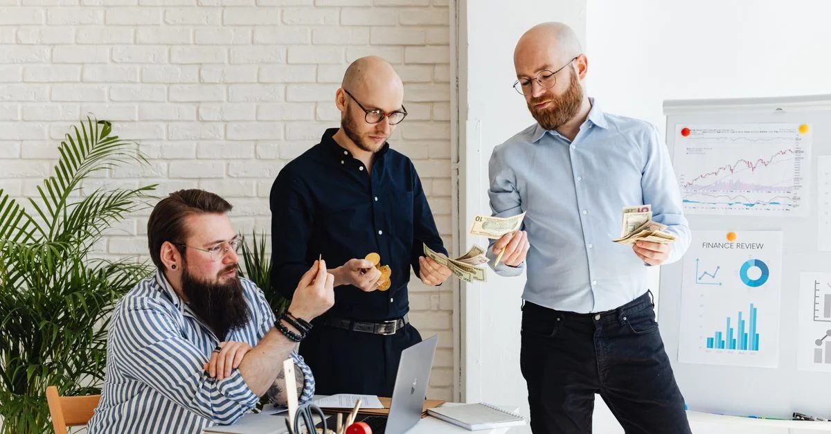 Drei Geschäftskollegen besprechen Finanzstrategien und überprüfen Diagramme in einem modernen Büro.