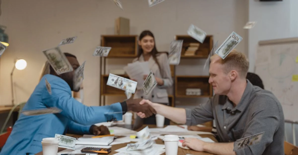 Geschäftsleute schütteln sich die Hände, während Geld herabfällt, was finanziellen Erfolg symbolisiert.