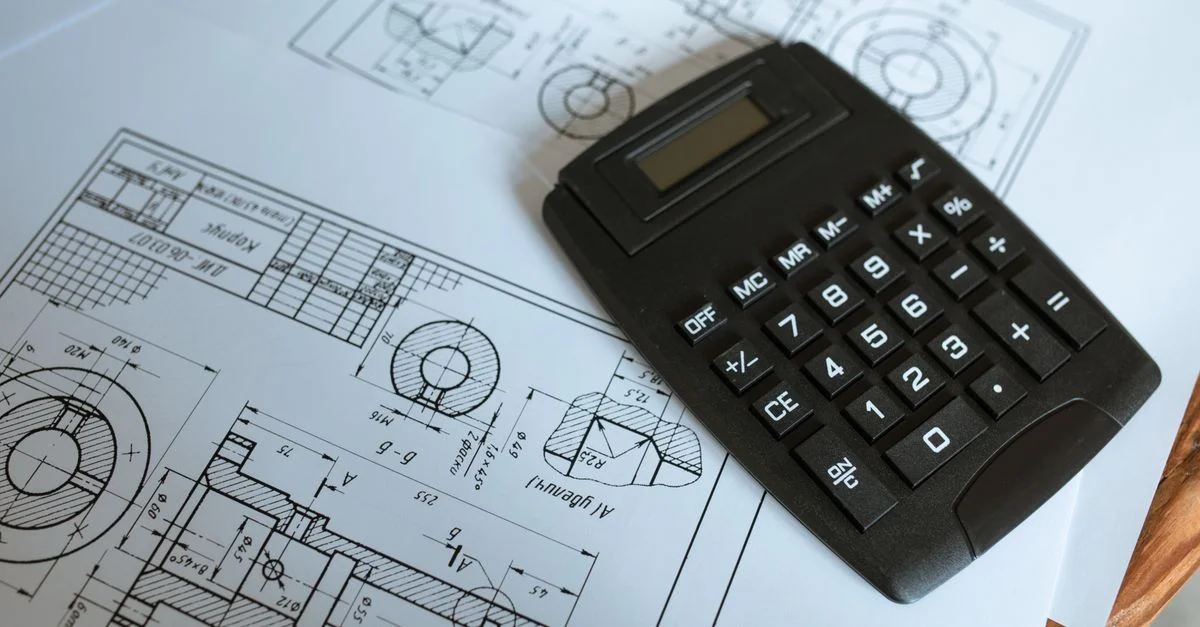 Nahaufnahme eines Taschenrechners auf technischen Ingenieursplänen, der präzise Berechnungen zeigt.